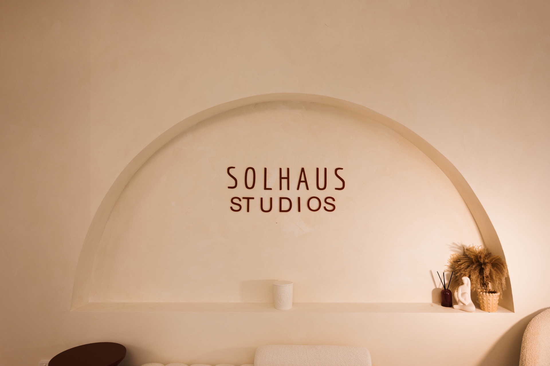 The arched Solhaus Studios signage above the studio reception shelf